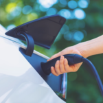 A person charging an electric vehicle
