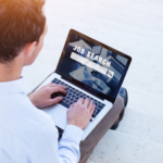 A person on a laptop with the phrase "job search" on its screen.